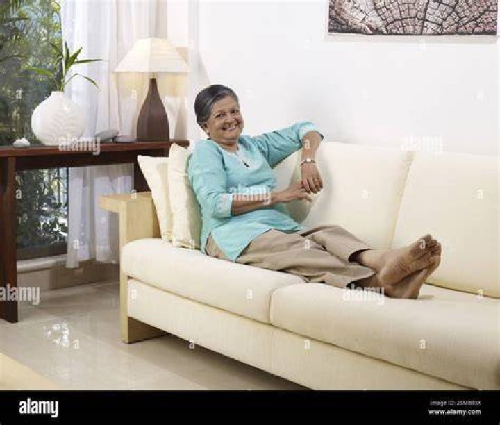 A lady relaxes in the sunshine in Green Park, London