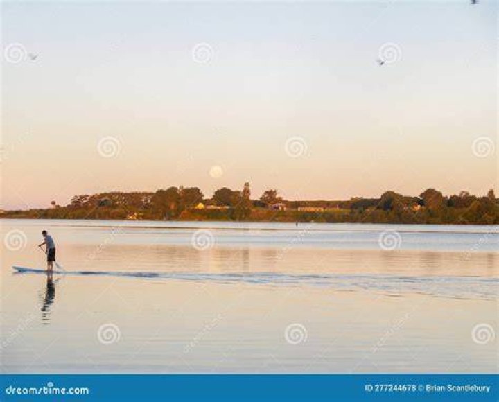 A paddle boarder passes by the West Pier in Brighton on a beautiful sunny morning