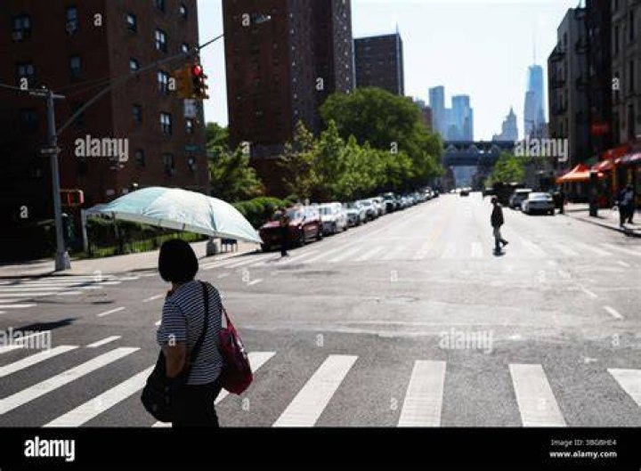 A pedestrian shields themselves from the rain on Sunday