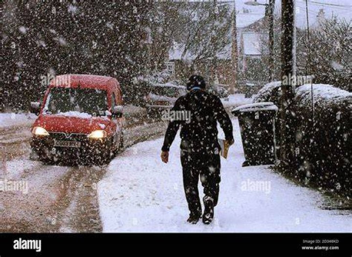  A postman braves the conditions in shorts whille doing his rounds in Stalybridge, Greater Manchester