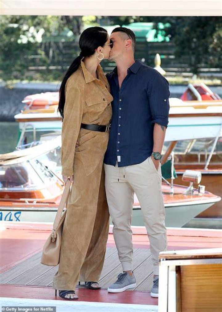 Adriana Lima goes braless beneath white blazer as she joins dapper beau