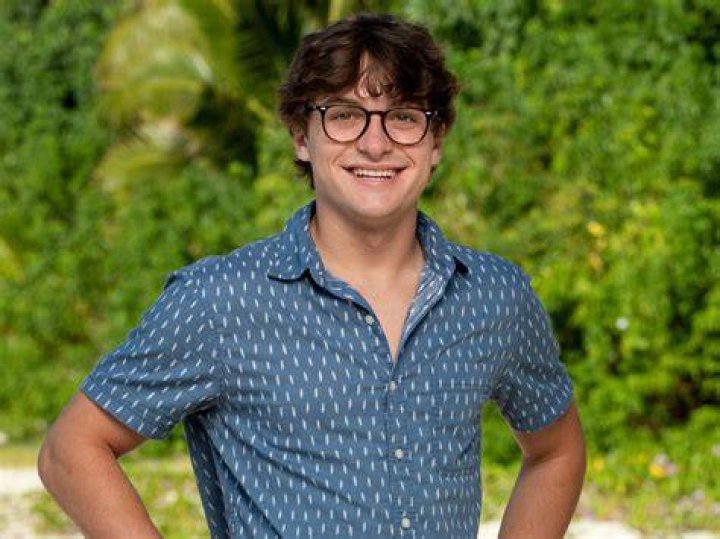 Carson Garrett in Survivor 44 smiling in a red shirt