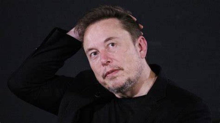 Elon Musk rubbing his head