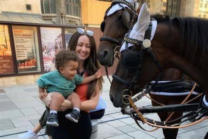 Emily Magny Holds Her Son, Liam Magny As He Tries To Touch A Horse