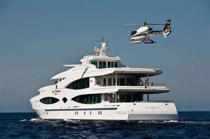 Helicopters and yachts depart from a beach as the fires approach