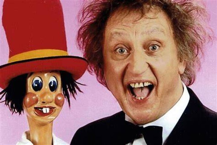 Ken Dodd posing with his statue at Liverpool's Lime Street Station in 2014