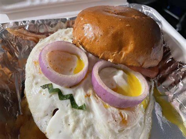  This burger seems to have an evil look in its eye as it stares out from this person's arm