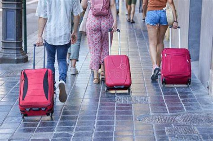 Tourists wheel their suitcases down the road as they escape the fires in Bodrum