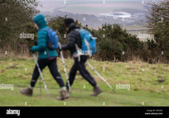  Two ramblers make their way across a field in the Peak District